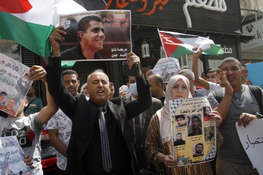 Palestinians seen holding portraits showing prisoners,